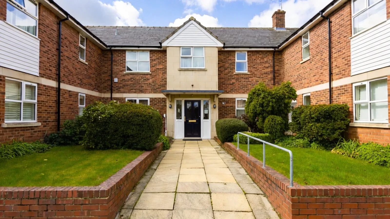 Brick residential courtyard entrance with path and lawns