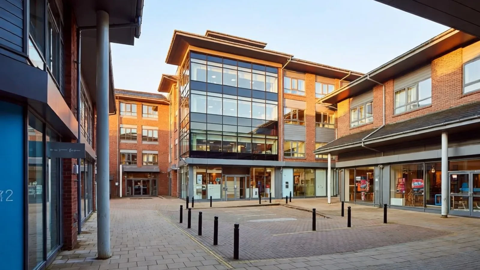 Office courtyard with shops and brick buildings at sunset
