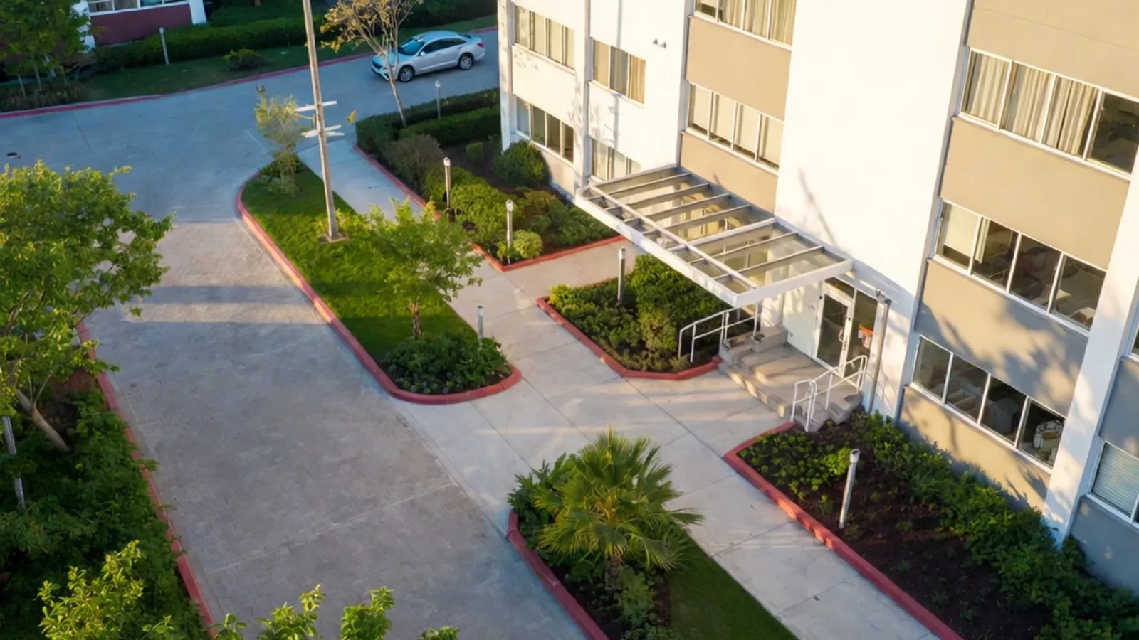 Aerial view of white apartment building with canopy entrance