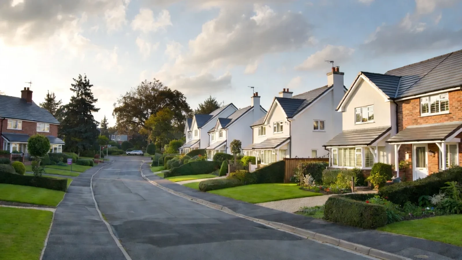 Suburban street with white houses and green lawns
