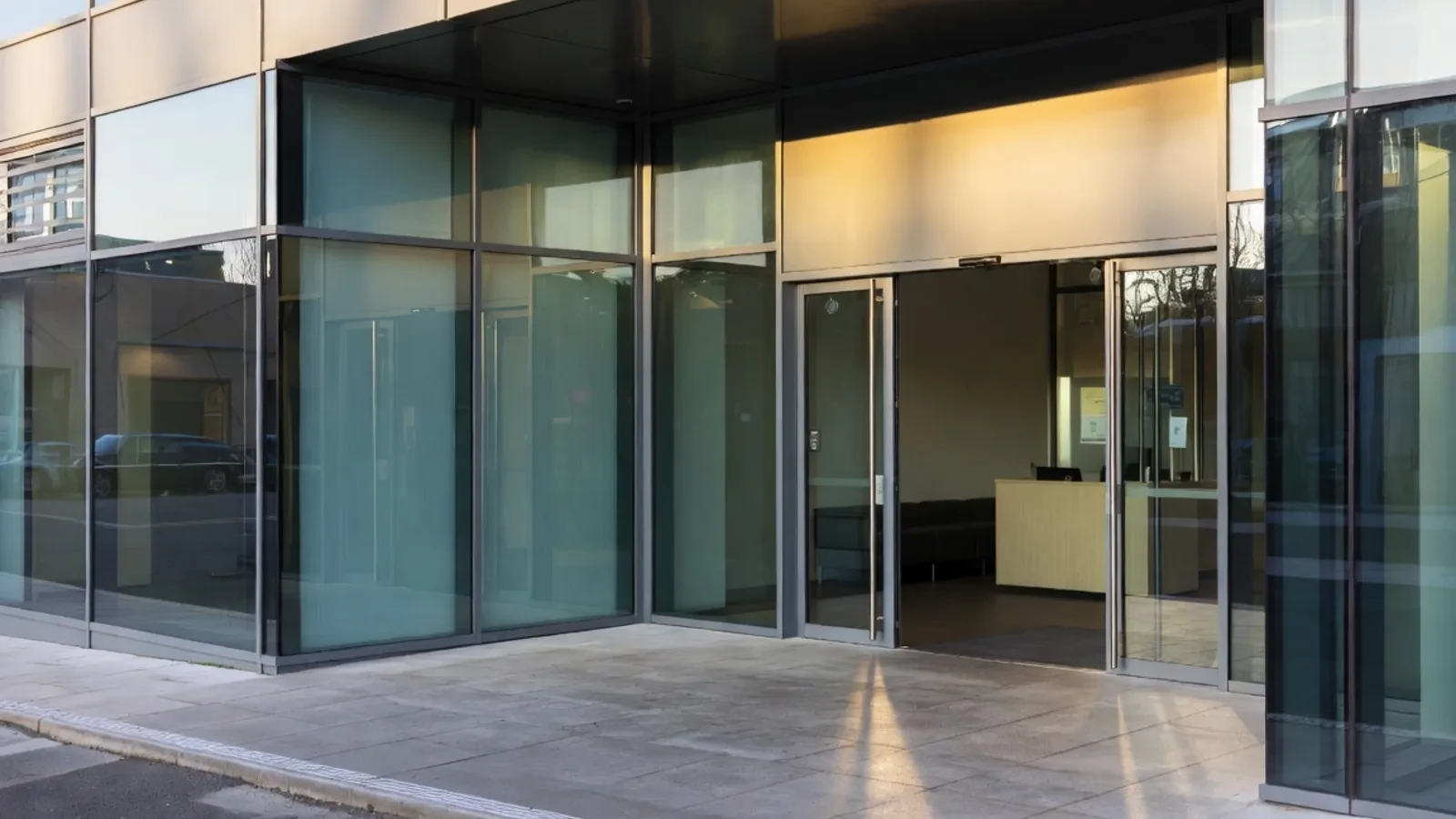 Modern office entrance with glass and reception desk visible