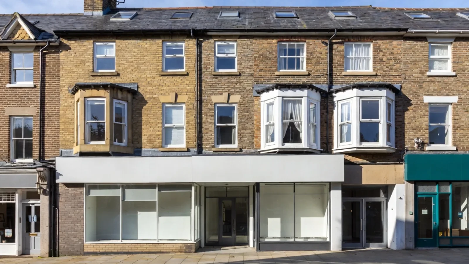 Terraced houses with empty shopfronts at street level